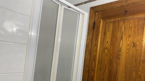 Une pièce avec une porte en bois, un mur blanc et une porte coulissante grise.