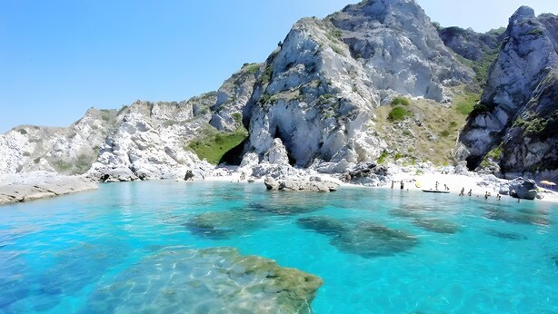 A coastal area with clear turquoise water, rocky cliffs, and a sandy beach. - Holiday Home 'Casa Nuovissima' with Sea View, Wi-Fi and Air Conditioning (Praia a mare)
