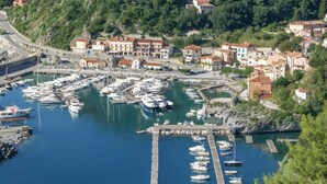 A marina with boats docked, surrounded by residential buildings and a hilly landscape. - Holiday Home 'Casa Nuovissima' with Sea View, Wi-Fi and Air Conditioning (Praia a mare)