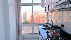 A modern kitchen with a large window, a stove, and a sink. - 12 min to Majorelle 2BR Oasis AC & Free Parking (Marrakesh)