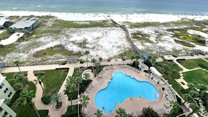 A resort with a swimming pool, beach access, and a view of the ocean.
