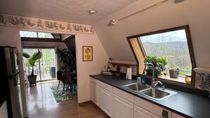 A kitchen with a large window, white cabinets, and a refrigerator. - 474, Your Mountain Getaway. (Keyser)