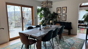 A dining area with a table, chairs, a chandelier, and a large plant. - 474, Your Mountain Getaway. (Keyser)