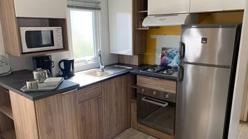 Een koelkast, een broodrooster, kookgerei, borden en bestek