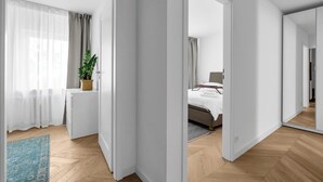 A modern hotel room with a bed, a desk, and a potted plant. - Warszawa Rakowiec Stylish Apartment (Warszawa)