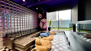 Ein moderner Lounge-Bereich mit Schachbrettfußboden, einer Ledersofa und einer Wand aus dekorativen Glaspaneelen.