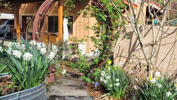 A two-story house with a red roof, brick exterior, and a wooden porch. - The Nest in South Eugene (Eugene)