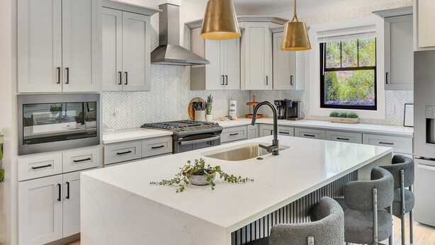 A modern kitchen with white cabinetry, a central island, stainless steel appliances, and pendant lighting. - Dolly-Themed 3BR Luxury Retreat w/ Arcade, Hot Tub & Lanai – Near Dollywood (Sevierville)