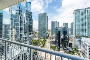 Un quartier urbain caractérisé par de grands immeubles modernes, un ciel dégagé et une rue animée par la circulation.