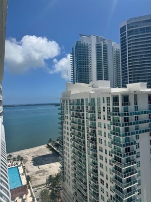 A high-rise hotel with multiple floors, a pool area, and a view of the ocean.