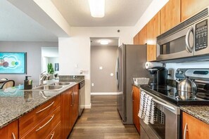 Eine moderne Küche mit Granit-Arbeitsplatten, Edelstahlgeräten und Holzausstattung.