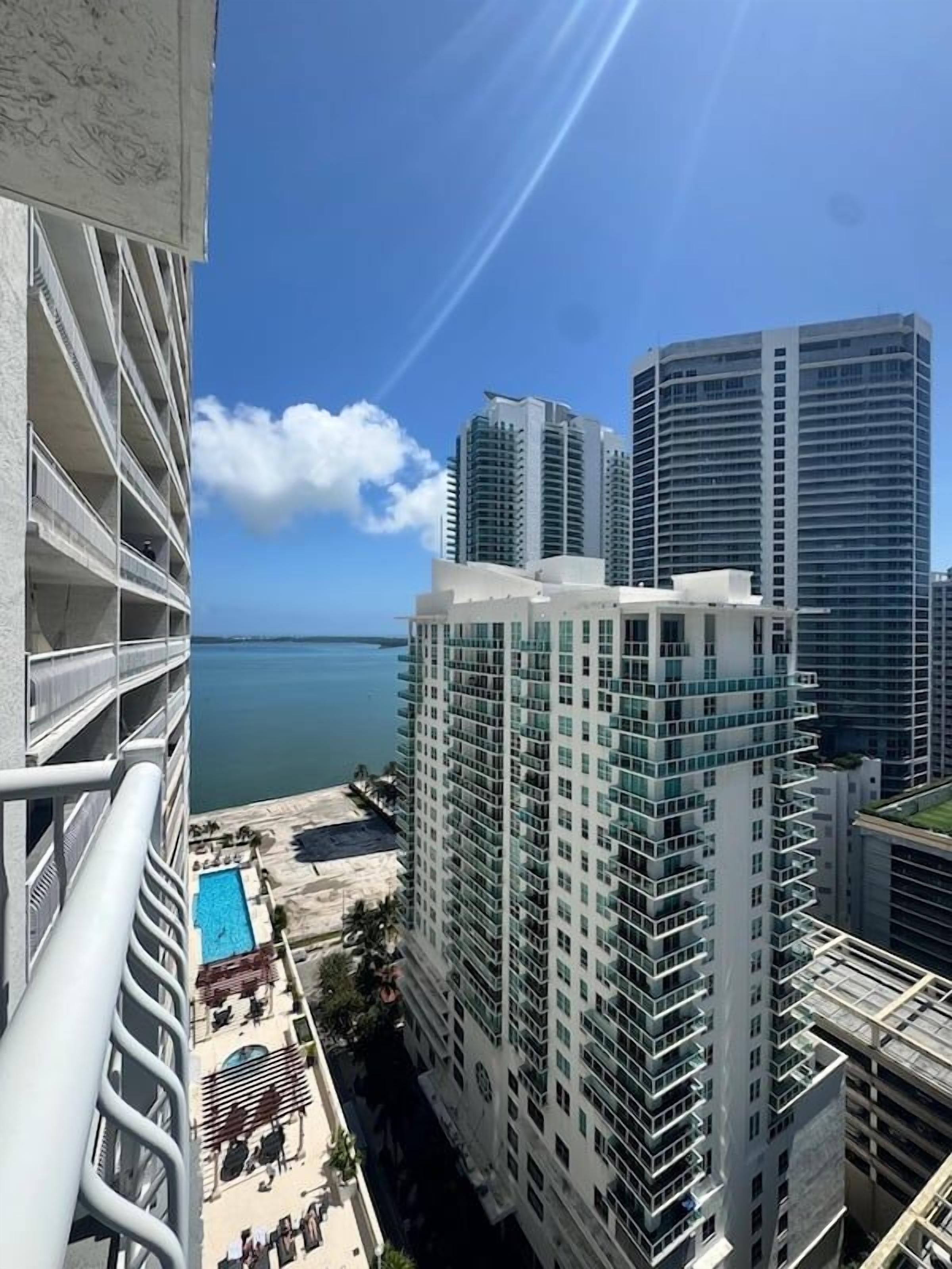 A high-rise hotel with multiple balconies overlooking a beach and the ocean.