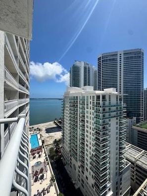 A high-rise hotel with multiple balconies overlooking a beach and the ocean.