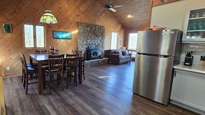 Un intérieur de chalet chaleureux comprenant un coin repas, un salon et une cuisine.