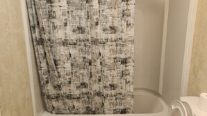 A bathroom with a shower curtain, a toilet, and a sink. - 3 bedroom, 2 bathroom across from Walmart, 5 minutes to the airport & hospital. (Yellowknife)