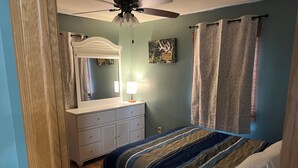 A bedroom with a bed, dresser, mirror, and a ceiling fan. - The Bohemian Bungalow  near Main Street in Scenic Verdigre, Nebraska (Verdigre)