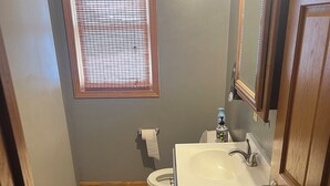 Ein kleines Badezimmer mit Toilette, Waschbecken und Fenster.