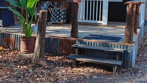A rustic cabin with a porch, a potted plant, and a wooden bench. - 2 Cabins 1 Price Themed Cabins 2 Miles from Trade Days (Canton)