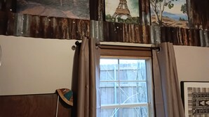 A room with a window, a curtain, and a wall with three paintings. - 2 Cabins 1 Price Themed Cabins 2 Miles from Trade Days (Canton)