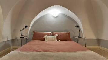 Ein Schlafzimmer mit einem Bett, zwei Nachttischen und einer Lampe auf jedem Tisch.