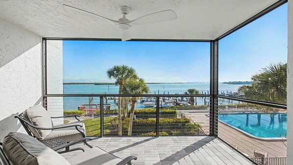 Un balcon avec vue sur un port de plaisance et une piscine.