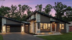 A modern two-story house with a stone facade, large windows, and a garage. - The Timberline @ Spring Brook Resort (Wisconsin Dells)