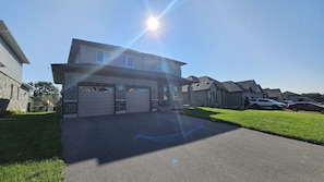A residential house with two garages, a driveway, and a lawn.