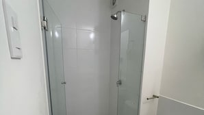 A bathroom with a glass-enclosed shower, a toilet, and a sink. - Mini loft in front of malecon Bertolotto (minutes from Costa 21 and airport) (San Miguel)