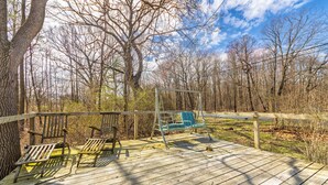A wooden deck with two chairs and a swing set. - Dune's Edge Retreat Peaceful home near State park and trails (South Haven)