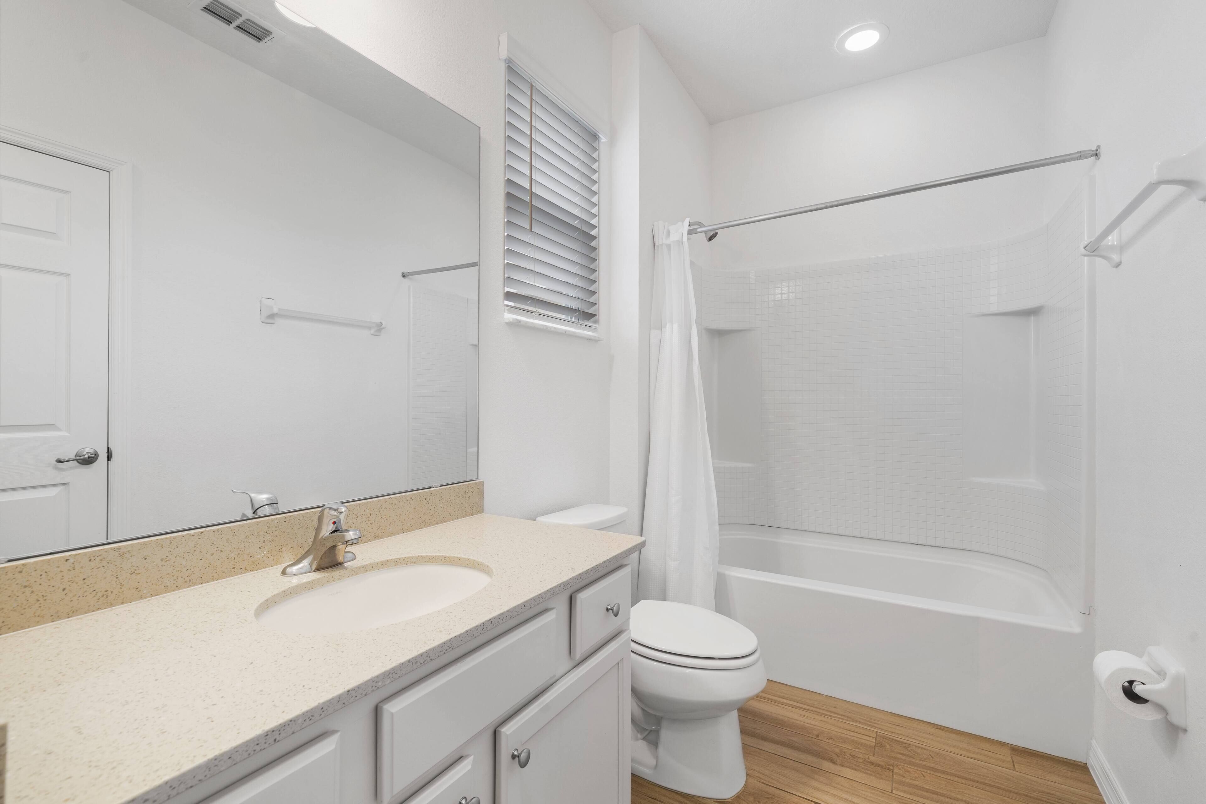 A modern bathroom with a sink, toilet, and shower area.