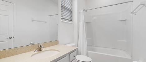 A modern bathroom with a sink, toilet, and shower area.