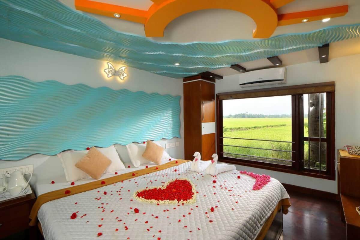 Una habitación de hotel con una cama grande, vistas a un campo verde y un techo decorativo.