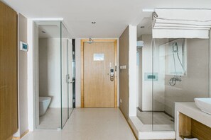 A modern bathroom with a glass shower enclosure, a wooden door, and a white sink. - Shuanglang 7 Fun sea Hotel (Dali)