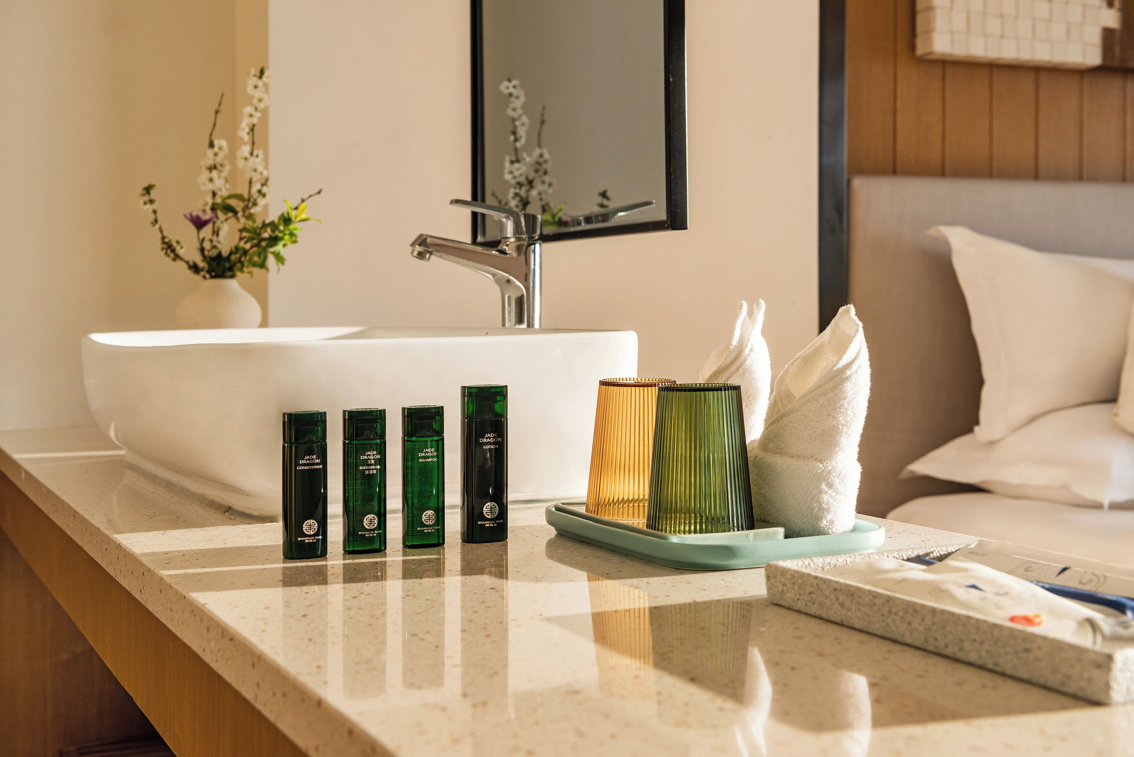 A bathroom with a white sink, a mirror, and toiletries on the counter.