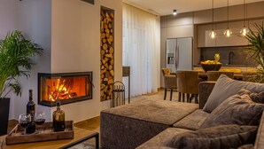 Una sala de estar moderna con chimenea, comedor y cocina.
