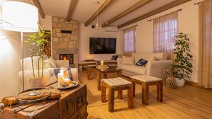 Un salon chaleureux avec une cheminée en pierre, des meubles en bois et un téléviseur.