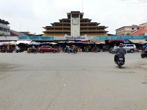 A market area with a prominent building featuring a clock tower.