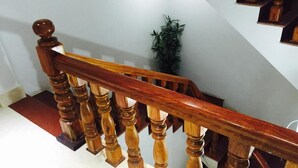 Uma escada de madeira com corrimão e balaústres.