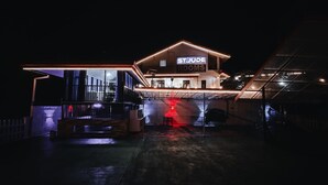 En byggnad med en skylt som visar texten ”ST. JUDE ROOMS” på natten.