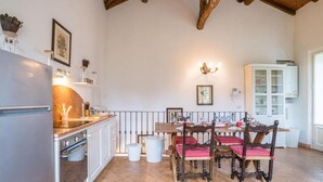 Una cocina con una mesa de comedor, sillas, refrigerador, armarios e iluminación.