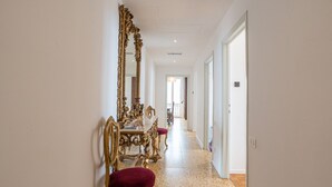 Un pasillo con comedor que presenta muebles dorados ornamentados y un espejo grande.