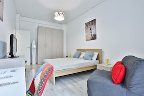 Quarto moderno com uma cama, escrivaninha, cadeira e um pôster na parede.
