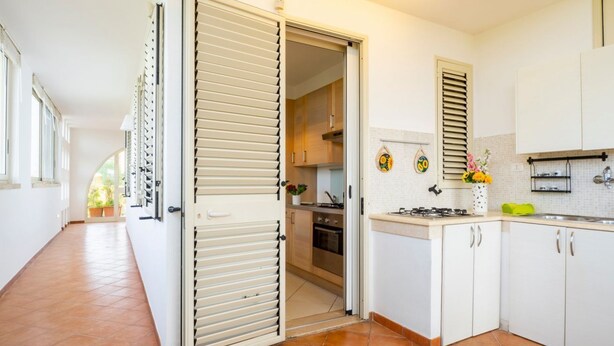 A kitchen with white cabinets, a stove, and a sink. - GuestHost - Villa Mirò - Escape to Salento (Melendugno)