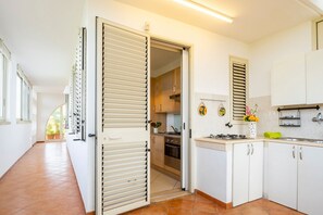 A kitchen with white cabinets, a stove, and a sink.
