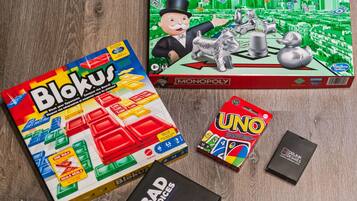 A Monopoly board game, Blokus, UNO, and a box labeled BAD Choices.