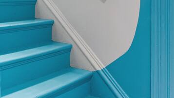 Eine Treppe mit blauen Stufen und einer weißen Wand.