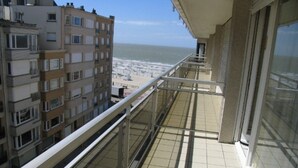 A balcony with a view of the beach and other buildings. - Modern 5th Floor Apartment (Knokke-Heist)