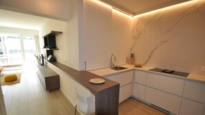 A modern kitchen with a marble backsplash, a built-in sink, and a wooden countertop. - Modern 5th Floor Apartment (Knokke-Heist)