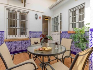 A round glass table with chairs, a bottle of wine, and a plate of food. - Ocean Glow Living4malaga (Málaga)