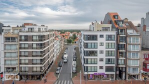 A multi-story building with a central courtyard, featuring balconies and a mix of residential and commercial spaces.